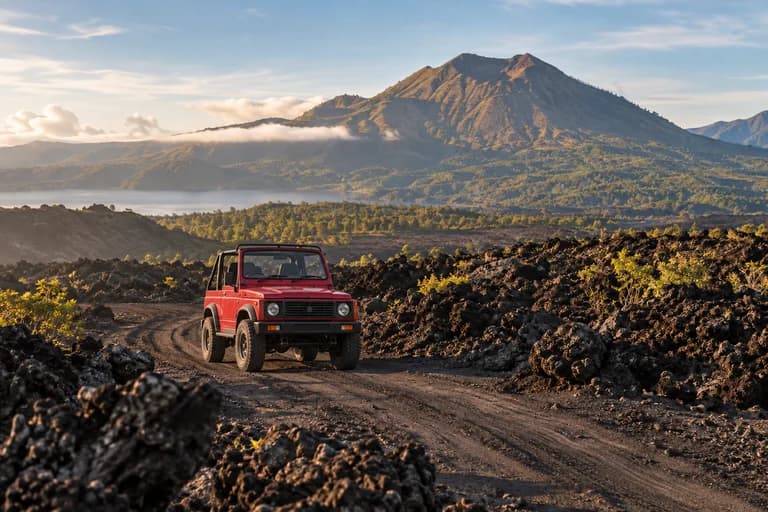Illustration of a small jeep on Mount Batur’s black sand and lava terrain