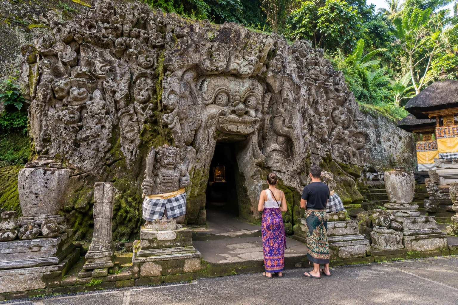 Illustration of visitors at the carved entrance of Goa Gajah